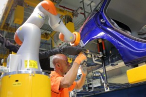 Im Kölner Werk von Ford arbeiten Mensch und Maschine Hand in Hand. Der kollaborierende Roboter hilft hier beim Einbau eines Stoßdämpfers.