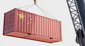Ein roter Frachtcontainer mit der chinesischen Flagge wird von einem Kran mit Stahlseilen angehoben.