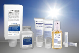 Mehrere Sonnenschutzprodukte der Serie Physioderm, darunter Lotion, Creme, Spray und Lippenpflegestift mit LSF 50, stehen nebeneinander vor einem sonnigen Himmel.