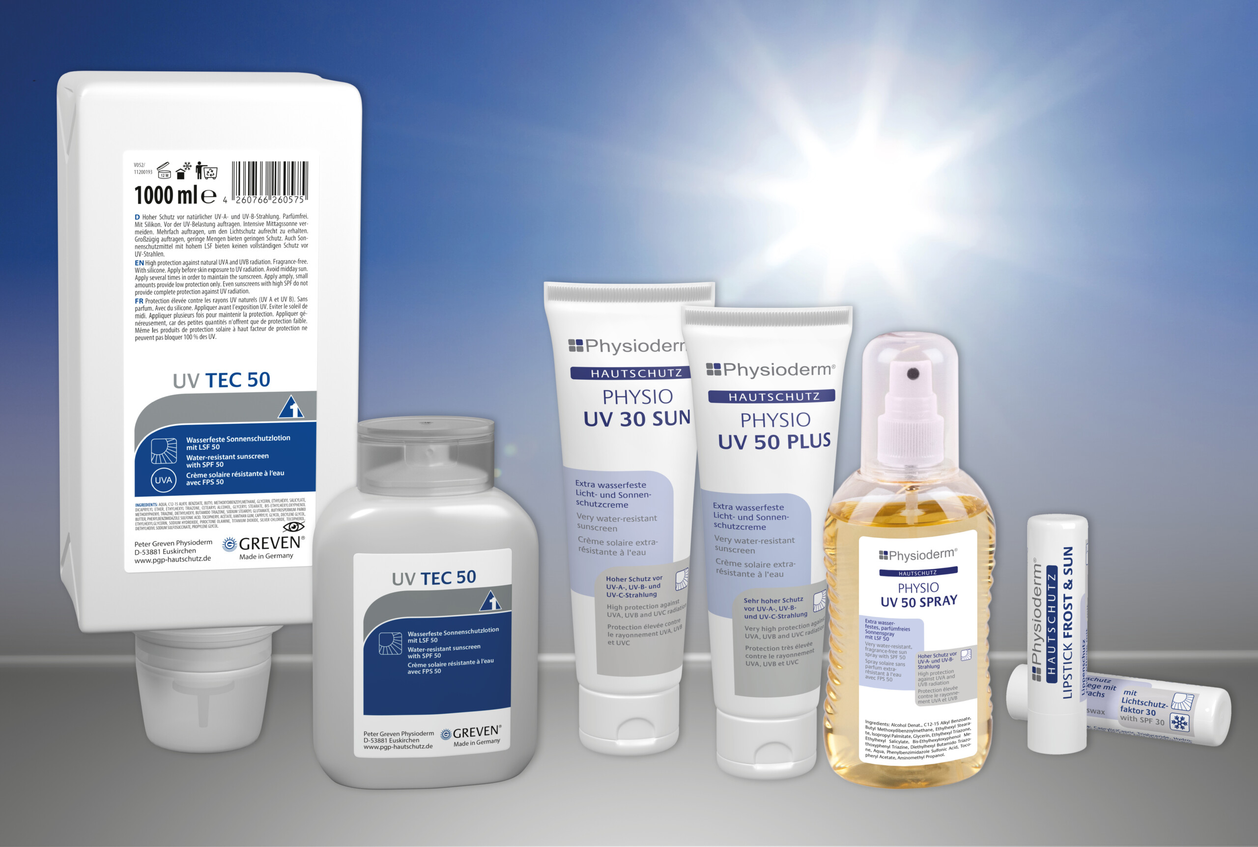 Mehrere Sonnenschutzprodukte der Serie Physioderm, darunter Lotion, Creme, Spray und Lippenpflegestift mit LSF 50, stehen nebeneinander vor einem sonnigen Himmel.