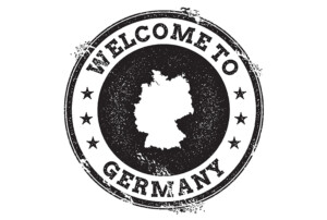 Schwarz-weißer Stempel im Grunge-Look mit der Silhouette Deutschlands in der Mitte und dem Text „WELCOME TO GERMANY“, umgeben von Sternen.